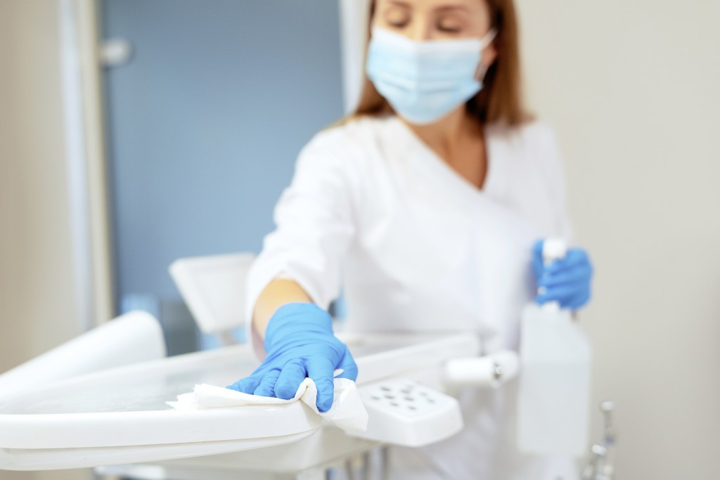 Woman cleaning and disinfecting dentist instruments