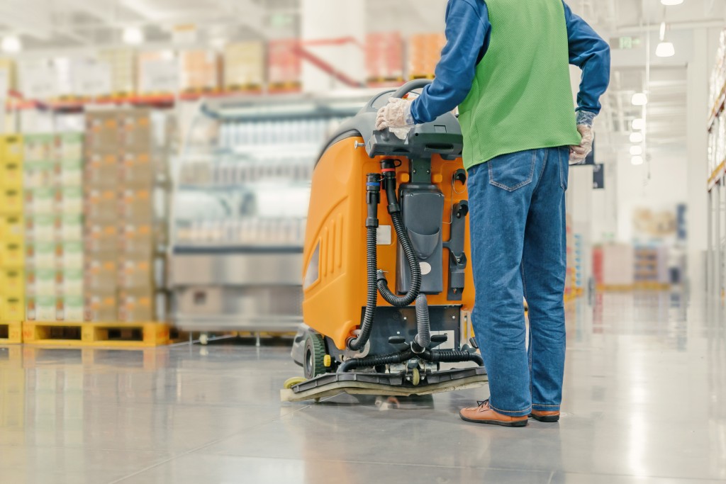 worker cleaning floor with machine
